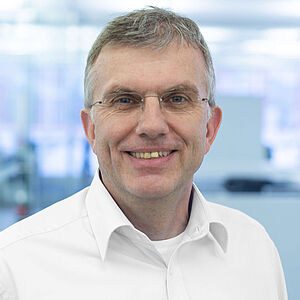 Smiling man in a white shirt.