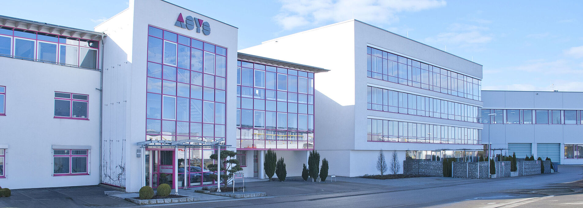 Gesamtansicht eines modernen Firmengebäudes der ASYS Group mit Glasfront.
