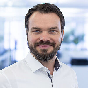 Smiling man in a white shirt.