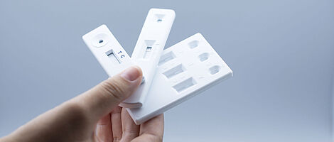 Hand holds 5 rapid tests