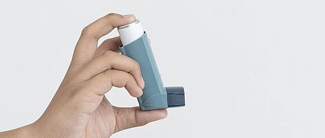 Hand holding inhaler