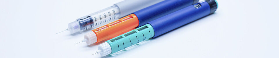 Three colored insulin pens next to each other