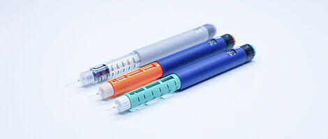Three colored insulin pens next to each other