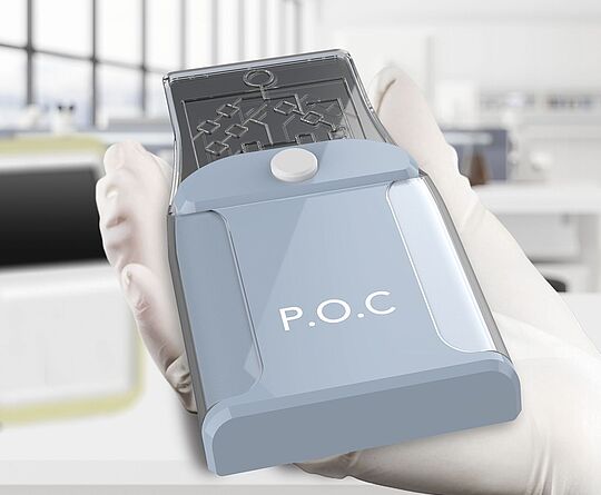 POC device in a hand with a glove, in the background a laboratory with a large window front