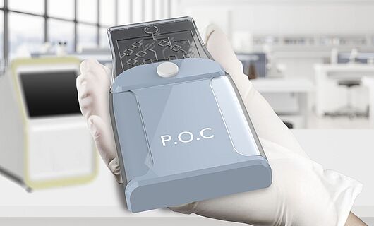 POC device in a hand with a glove, in the background a laboratory with a large window front