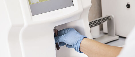 Person holding a test tube to a blood gas sensor